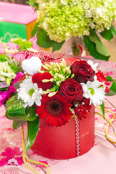 Compo de roses rouges et lfeurs blanche dans une boite rigide en cartons rouge